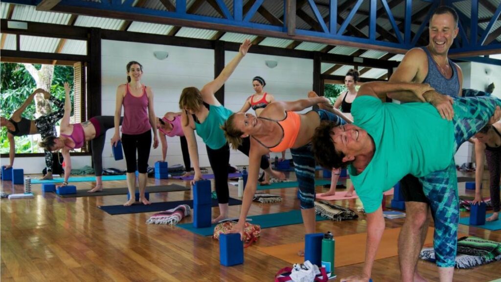 Yogi Aaron assisting a yoga student with half moon pose in Blue Osa's yoga shala in Costa Rica.