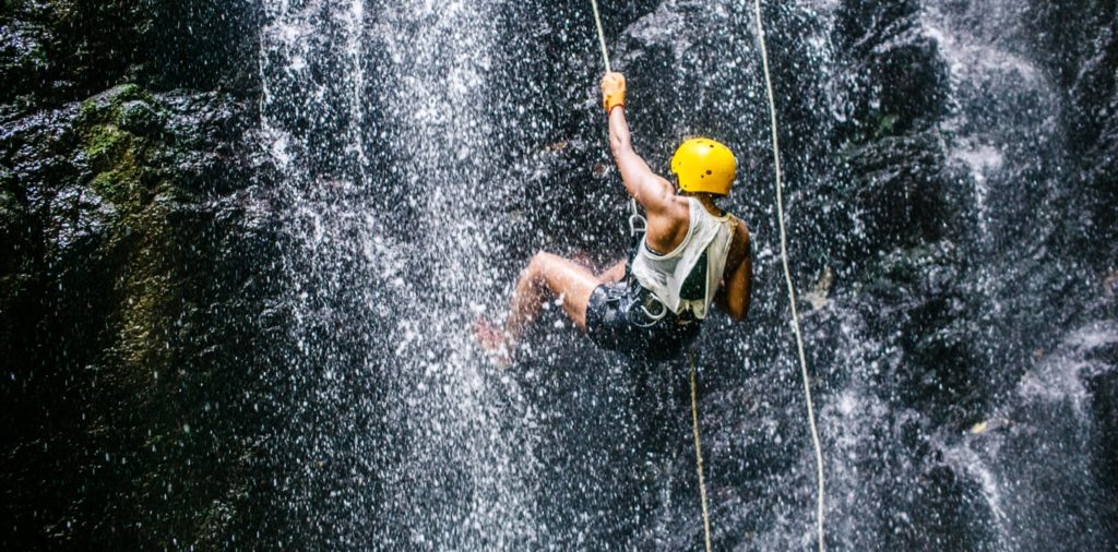 Man repelling down a waterfall on Blue Osa Yoga Retreat & Spa Horseback riding and water repelling waterfall eco-adventure in Costa Rica