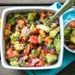 two bowls of salads with a citrus fruit on the side.