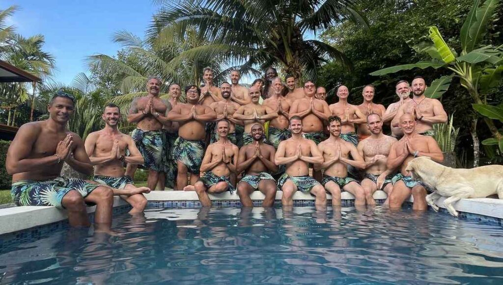 Men sitting on the ledge of the pool at Blue Osa Yoga Retreat & Spa during a gay men's retreat.