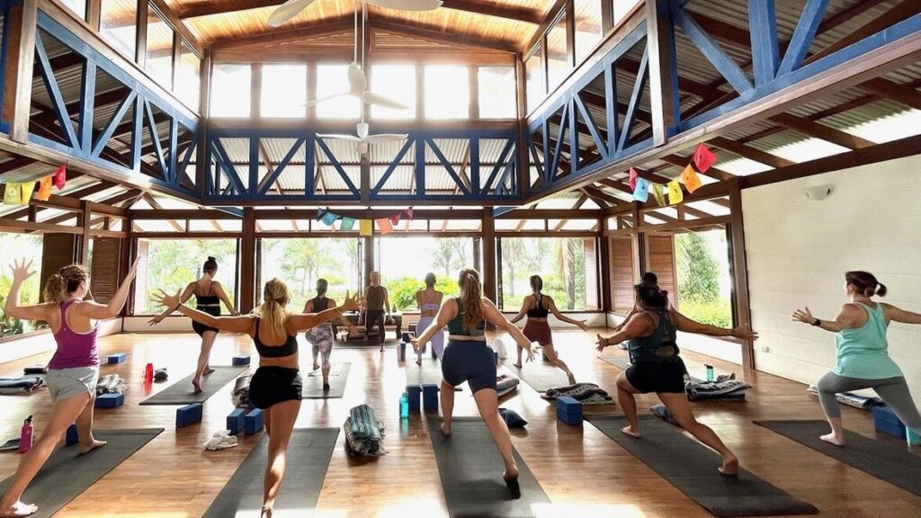 Yoga students doing a lunge pose in Blue Osa's yoga shala in Costa Rica.